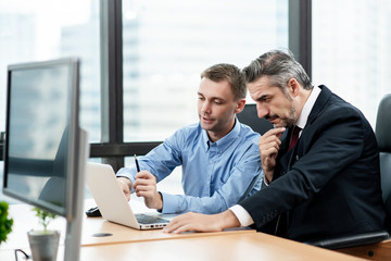 Caucasian office workers were use laptop to consulted with his boss.