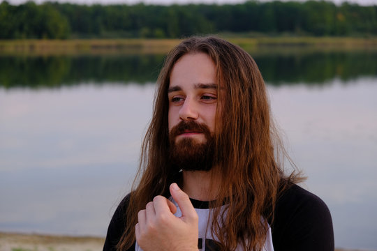 Portrait of handsome bearded young man with long hair
