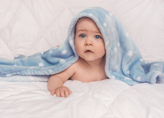 Fototapeta na wymiar Sweet little blue eyes baby boy portrait with blue blanket on white background
