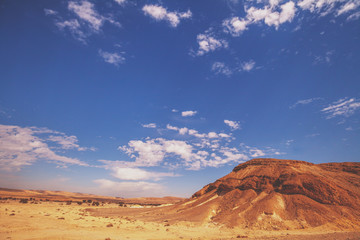 Mountainous desert with cloudy sky. Desert on a sunny day