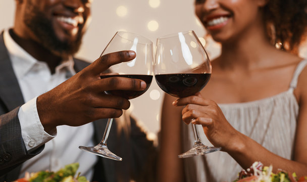 Close up of african couple toasting with red wine