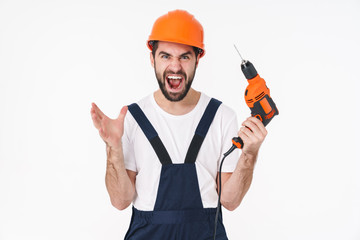 Man builder in helmet holding drill showing rock gesture.