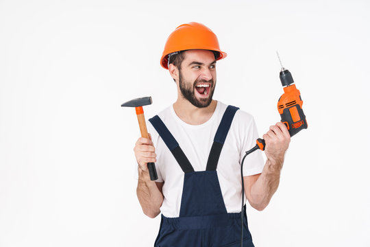 Young Man Builder Holding Drill And Hammer.