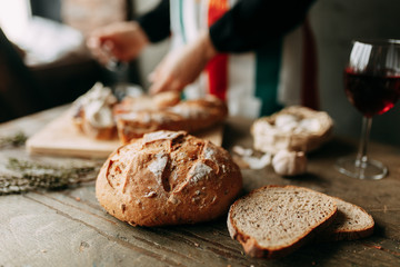  A loaf of white rye bread. Freshly baked bread. Girl's hands and cooking. Chef's table with pastries.
