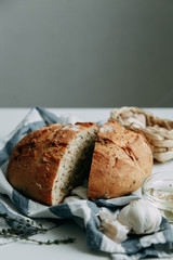 Cooking food with spices. A loaf of white rye bread. Sliced fresh bread on a towel.