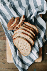  Garlic and thyme with pastries. A loaf of white rye bread. Sliced bread on a wooden Board. Slices on a towel.