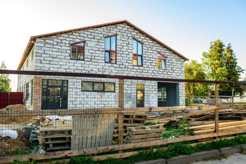 Unfinished house from a white brick. Construction of private houses.