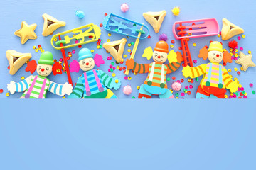 Purim celebration concept (jewish carnival holiday) over blue wooden background. Top view, Flat lay