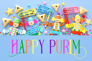 Purim celebration concept (jewish carnival holiday) over blue wooden background. Top view, Flat lay