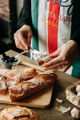 Making sandwiches on a wooden table. Home bread. The chef prepares bruschettas. Bread with cream cheese.