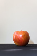 A one apple with drops of water on the black background. Macro