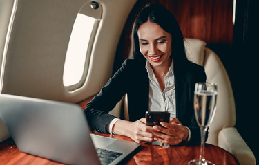 Business woman in private jet - obrazy, fototapety, plakaty