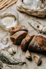 Baking on a wooden background. Fresh sliced white bread. Oil and olives with spices.