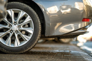 Closeup of a modern cars parked on a side of a city street on a sunny day.