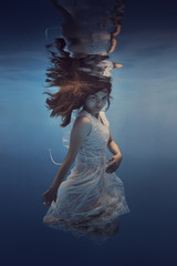 Portrait of a girl in a dress with lace underwater