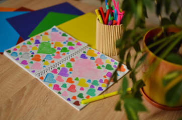 Multi-colored hearts drawn in a notebook. Close-up photo.