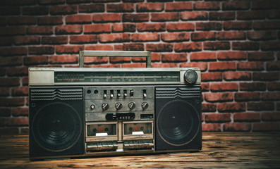 Retro stereo radio cassette recorders still life on table with brick wall background.