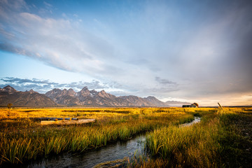 sunrise over mountain range and old homestead