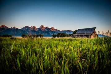 Sunrise with mountains and old barn