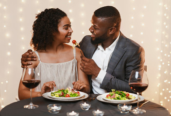 Couple in love feeding each other at restaurant