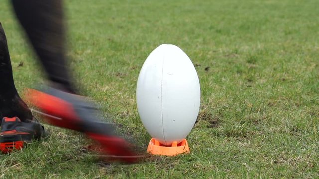 Kicking a conversion in Rugby. A player kicks the ball  off a tee during a match. Super Slow motion
