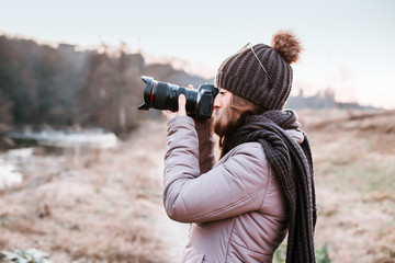 Female photographer talking pictures outdoor with camera. Nature photography