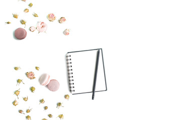 Notebook mock up, pencil and fresh roses on white wooden background . Top view, flat lay.