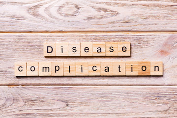 disease complication word written on wood block. disease complication text on wooden table for your desing, coronavirus concept top view