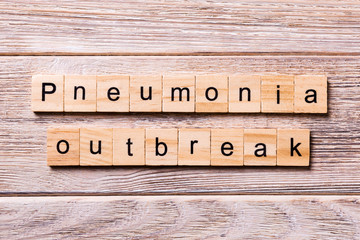 pneumonia outbreak word written on wood block. pneumonia outbreak text on wooden table for your desing, coronavirus concept top view