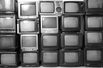 Black and white stack of old tv. Retro old television pile background.