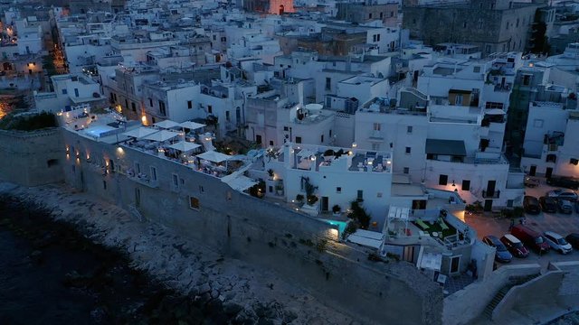 Aerial view, flight at the old town of Monopoli, at dusk, Puglia, Italy,