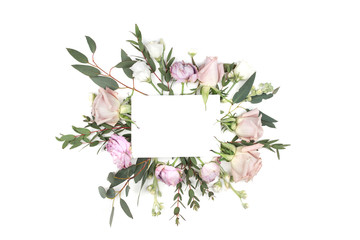 Empty paper blank on pink and white roses and leaves and petals with space for text. Flat lay. Top view