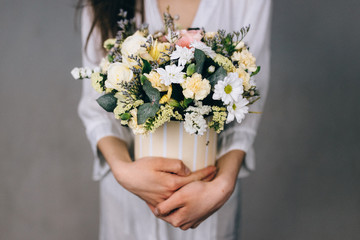 Woman florist making a lovely flower composition in a flower shop