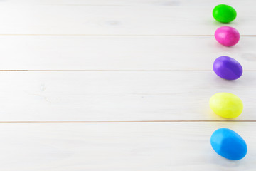 Multi-colored Easter eggs on a wooden table. Horizontal orientation, copy space.