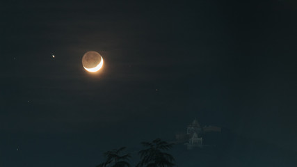 Fototapeta na wymiar Moon besides the temple on the hill at Wankaner, Gujarat, India