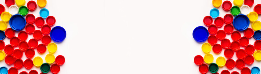 Colored plastic bottle's covers on white background, top view