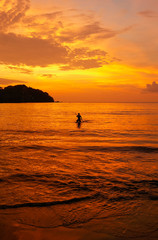 chica surfeando en el atardecer en la playa 