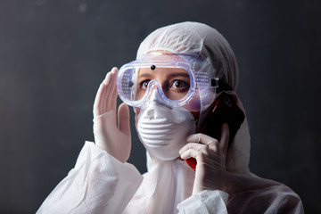 medic woman wearing protective clothing against the virus is using mobilephone for publicity