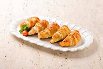 Fresh croissants on a ceramic plate. Perfect for a delicious breakfast or a snack in the afternoon