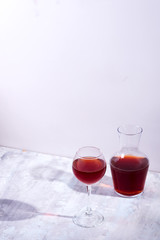 red wine in a wineglass with shadows isolated on stone background