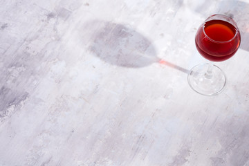 red wine in a wineglass with shadows isolated on stone background