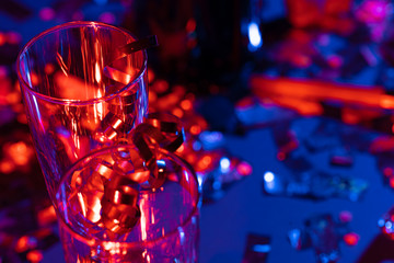 Champagne glasses with party tinsel on bright background