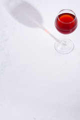 red wine in a wineglass with shadows isolated on stone background