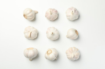 Flat lay with garlic bulbs on white background, top view