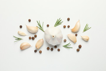 Flat lay of composition, garlic bulbs, slices, spice, parsley, rosemary on white background, top view. Space for text