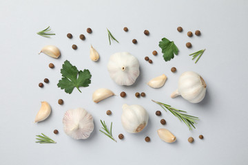 Obraz na płótnie Canvas Flat lay of composition, garlic bulbs, slices, spice, parsley, rosemary on grey background, top view. Space for text