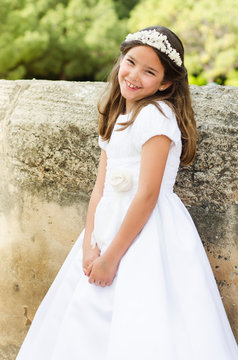 Beautiful young girl holding white dress for their catholic first holy communion