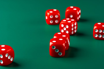 Red dice on green background close up