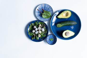 Flat lay of classic blue plates with appetizer with copy space on white background