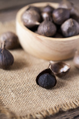 Black garlic on sack cloth and wooden table